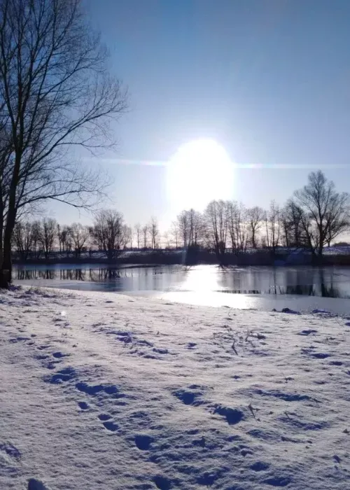 Łowisko Małe Samsieczno im Winter — zugefrorene Fläche und schneebedecktes Ufer